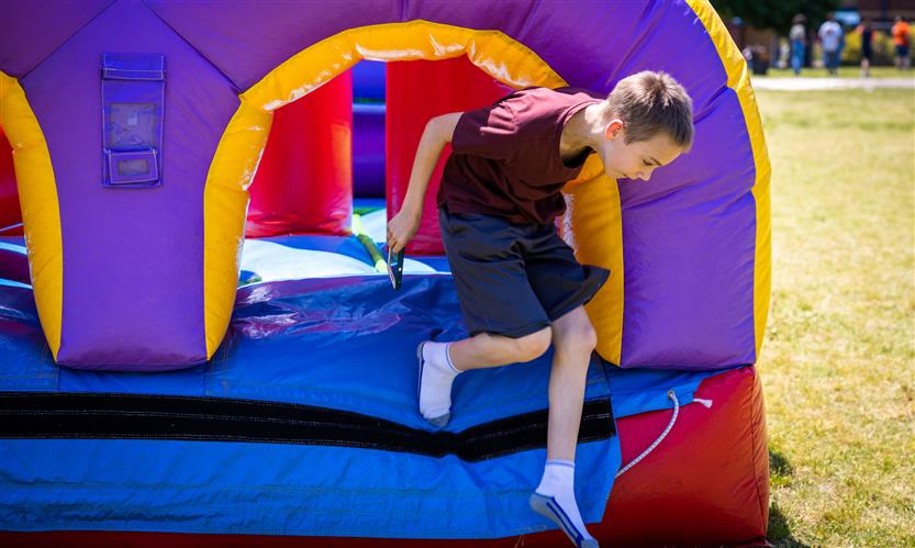 A boy jumps out of an inflatable obstacle course